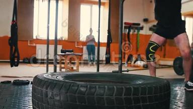 <strong>体育训练</strong>-一个人在健身房用金属锤击一个大轮胎